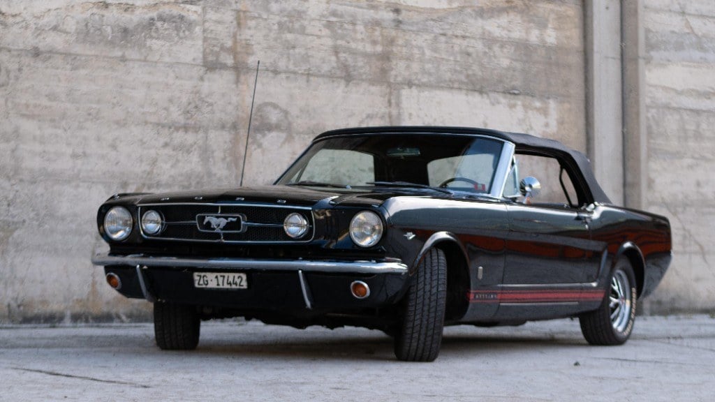 Schwarzer Ford Mustang Convertible der ersten Generation vor einer Betonwand