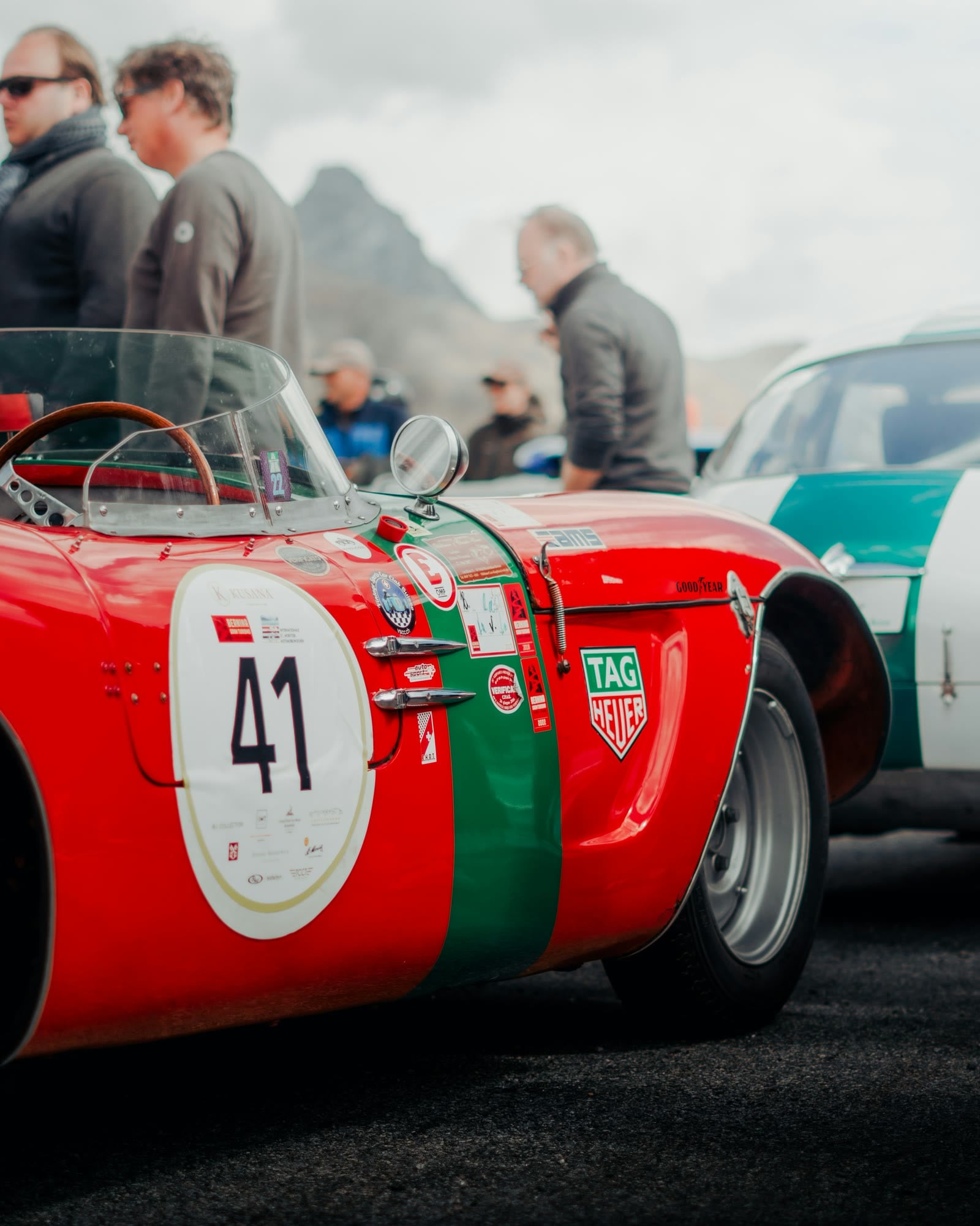 Rot-grüner Rennsportwagen mit Startnummer 41, dahinter Zuschauer und Berggipfel